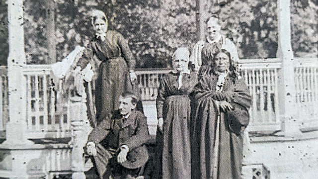 Photographer John N. Choate Portrait of Richard Henry Pratt and Chief Spotted Tail with Rebecca T. Haines (standing at left), Susan Longstreth (standing in center), and Mary Anna Longstreth (standing at rear right). The Longstreths and Haines were known as the "Quaker Ladies." All are posed on the bandstand on the school grounds. Spotted Tail was visiting the school in June 1880, which is probably when this photo was taken.