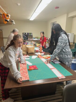 People sewing for the Pan African Sisterhood Health Initiative.