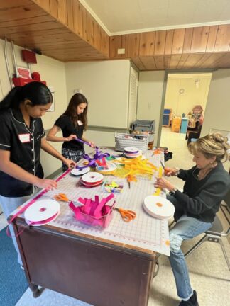People sewing for The Pan African Sisterhood Health Initiative.